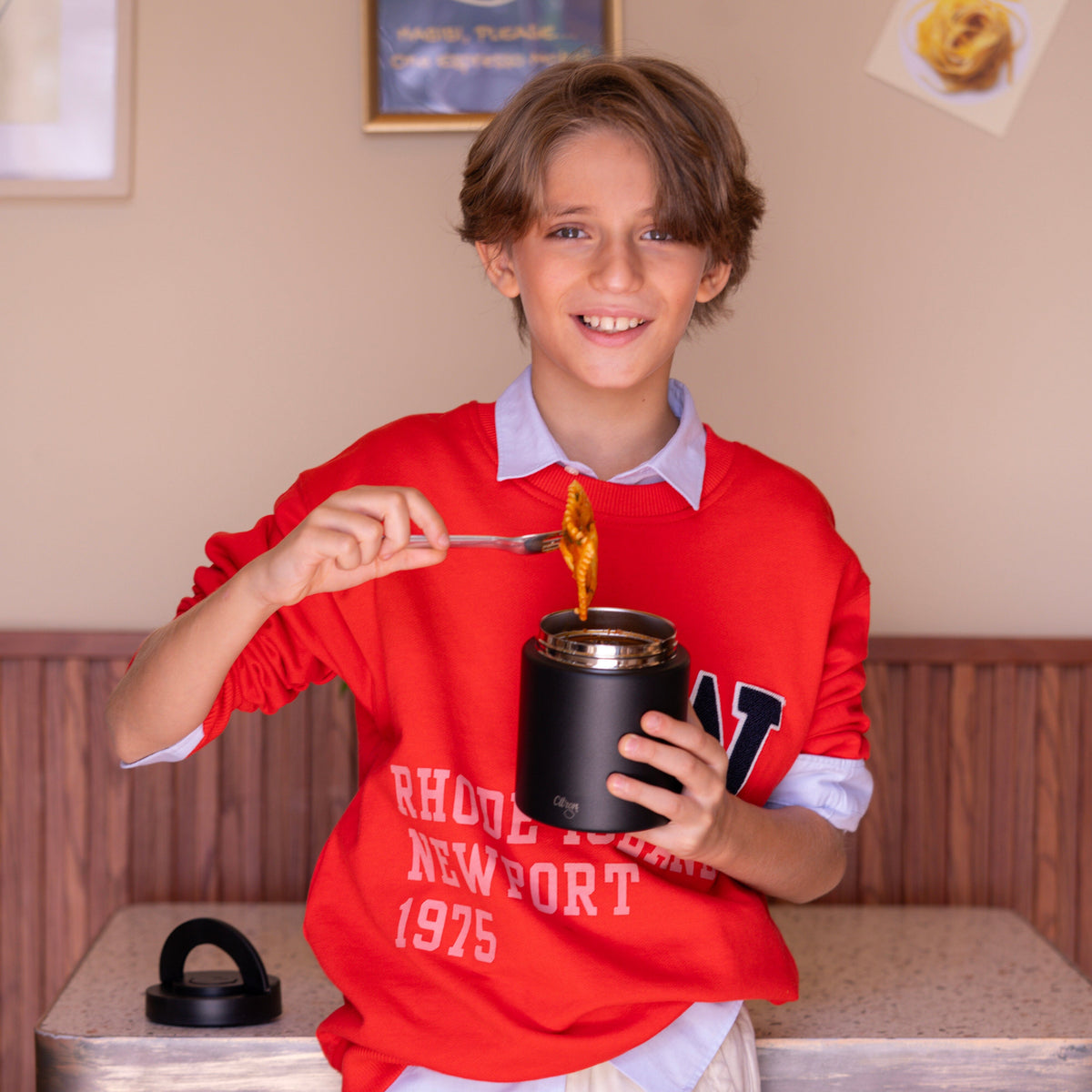 Child holding a Citron Black food jar